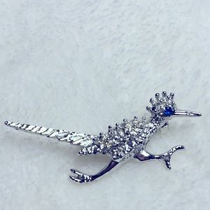 Silver tone metal roadrunner brooch with blue stone eye